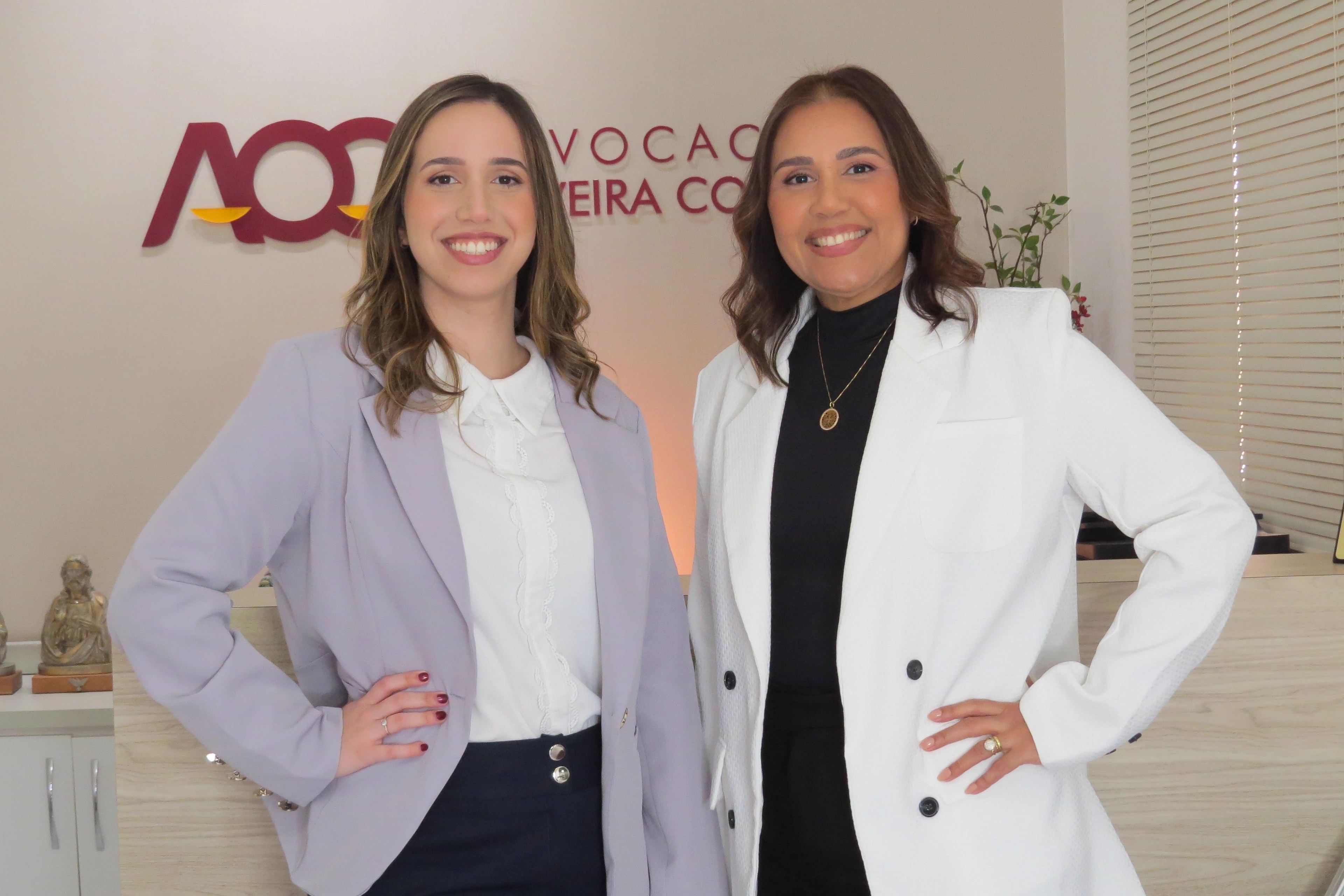 Duas advogadas da Advocacia Oliveira Costa na recepção do escritório, sob a marca da banca