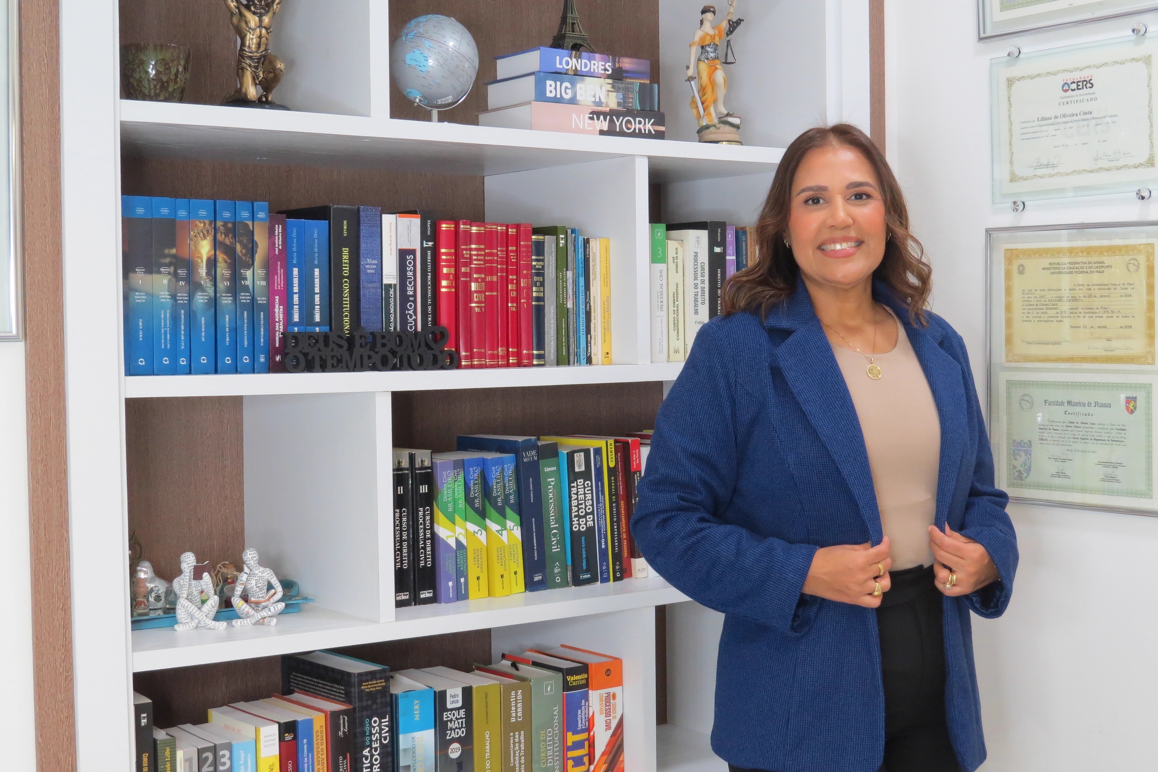 Sócia fundadora da Advocacia Oliveira Costa junto à estante de obras jurídicas do escritório